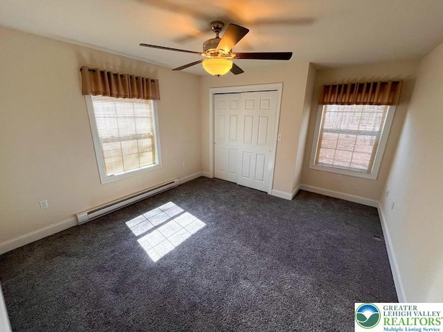 unfurnished bedroom with a baseboard radiator, dark colored carpet, baseboards, a ceiling fan, and a closet