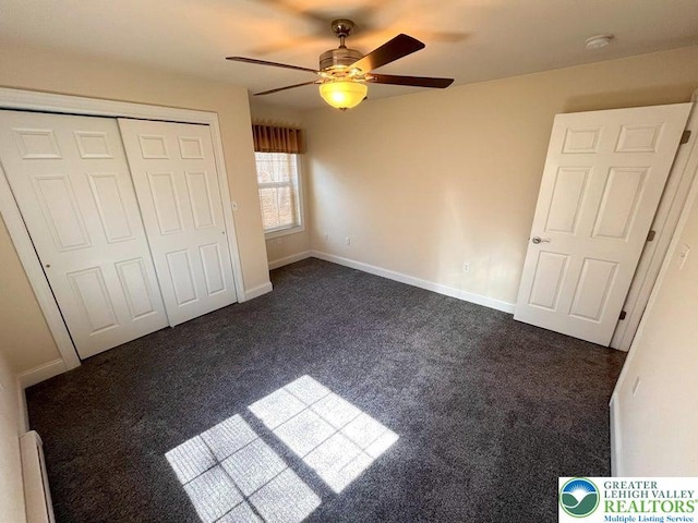 unfurnished bedroom featuring dark carpet, a closet, a ceiling fan, and baseboards
