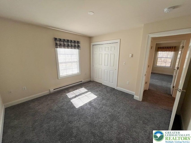 unfurnished bedroom featuring a baseboard radiator, carpet, baseboards, and a closet