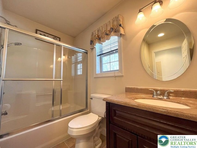 bathroom with vanity, toilet, combined bath / shower with glass door, and tile patterned flooring