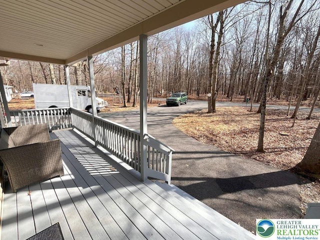wooden terrace with covered porch and view of scattered trees