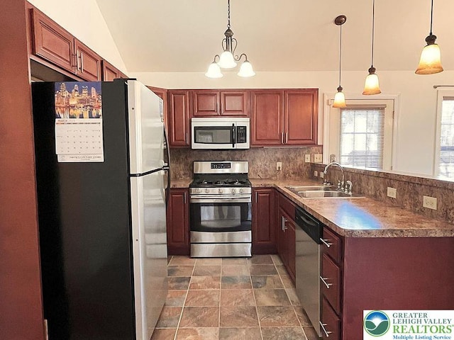 kitchen featuring appliances with stainless steel finishes, a sink, decorative backsplash, hanging light fixtures, and vaulted ceiling