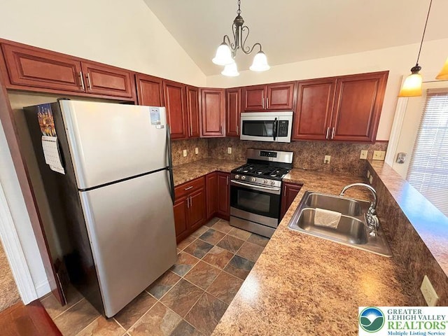 kitchen featuring appliances with stainless steel finishes, a sink, backsplash, hanging light fixtures, and lofted ceiling