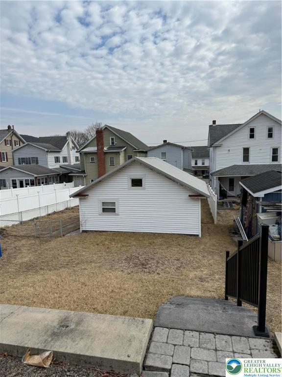 back of house featuring a residential view and fence