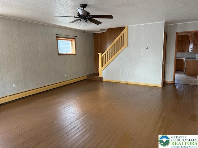 unfurnished living room featuring a baseboard radiator, ceiling fan, stairs, ornamental molding, and hardwood / wood-style flooring