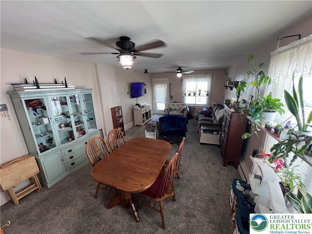 carpeted dining room with a ceiling fan
