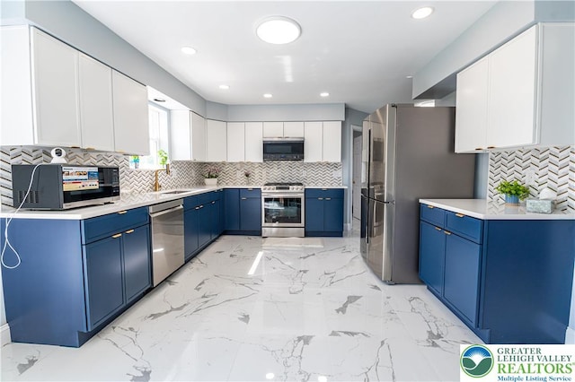 kitchen featuring appliances with stainless steel finishes, blue cabinetry, tasteful backsplash, light marble finish flooring, and recessed lighting