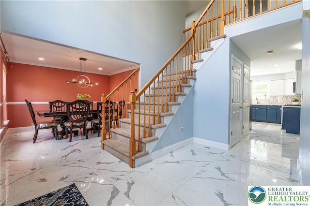 staircase with baseboards, a chandelier, recessed lighting, marble finish flooring, and a high ceiling