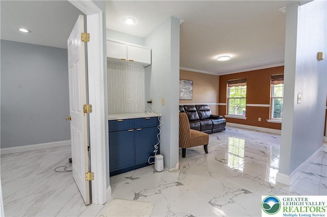 hallway with baseboards, light marble finish floors, and ornamental molding