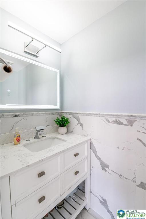 bathroom featuring vanity, tile walls, and wainscoting