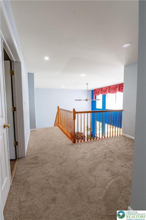 hallway featuring carpet floors, an upstairs landing, and recessed lighting