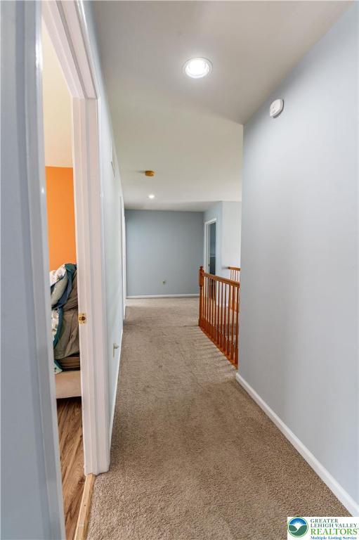 hall featuring carpet floors, baseboards, and recessed lighting