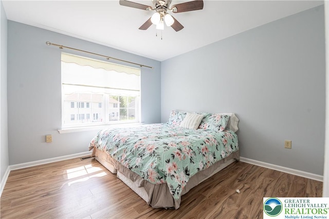 bedroom featuring wood finished floors, baseboards, and ceiling fan