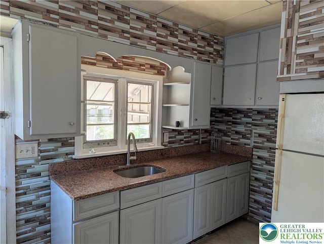 1616 W Tilghman St, Allentown City, PA 18102 - kitchen with a sink, freestanding refrigerator, open shelves, tasteful backsplash, and dark stone counters
