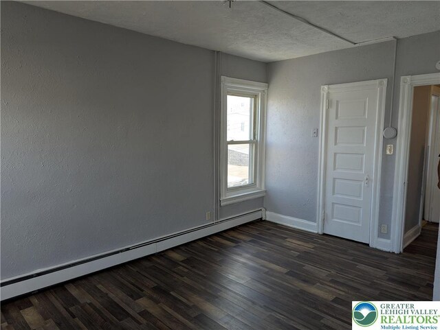 1616 W Tilghman St, Allentown City, PA 18102 - unfurnished room featuring baseboard heating, dark wood finished floors, baseboards, a textured ceiling, and a textured wall