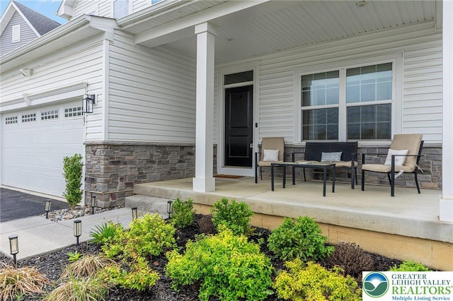 view of exterior entry with stone siding and a porch