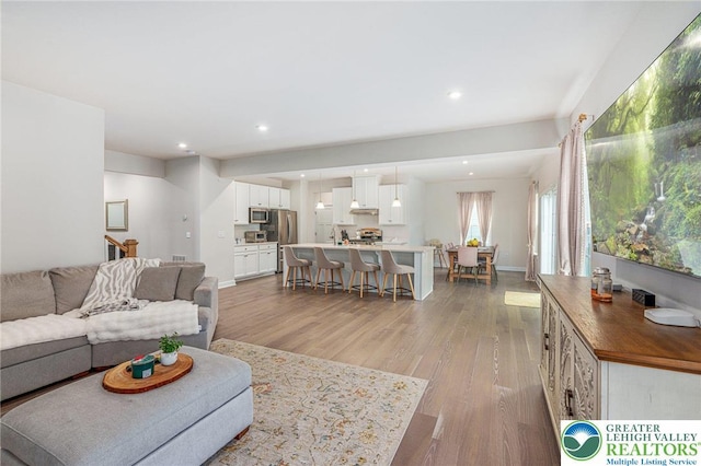 living area with light wood-type flooring and recessed lighting