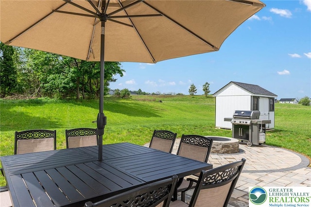 view of patio / terrace with outdoor dining area, an outdoor fire pit, a grill, and a shed