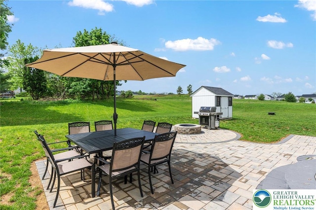 view of patio featuring a grill, a storage shed, a fire pit, an outdoor structure, and outdoor dining area