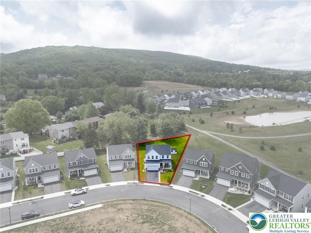 aerial perspective of suburban area featuring property boundaries highlighted and a heavily wooded area