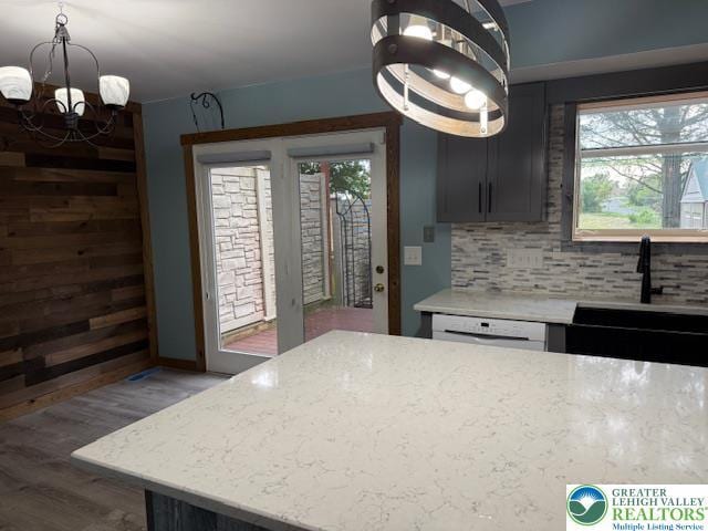 kitchen with a chandelier, wood finished floors, plenty of natural light, and tasteful backsplash