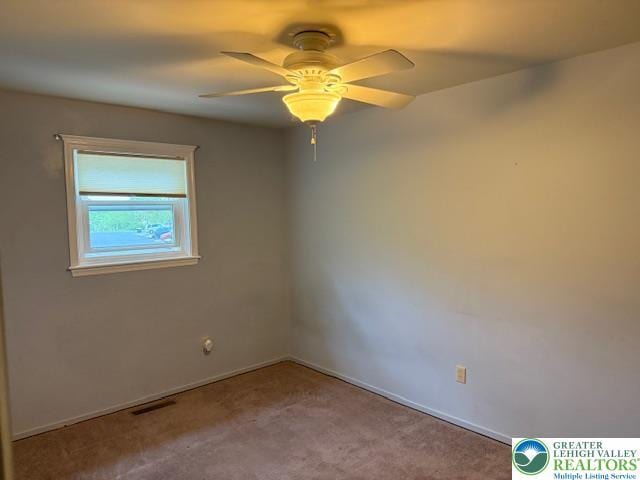 empty room featuring ceiling fan, carpet, and baseboards