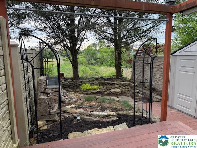 gate with a storage unit, an outdoor structure, and a wooden deck