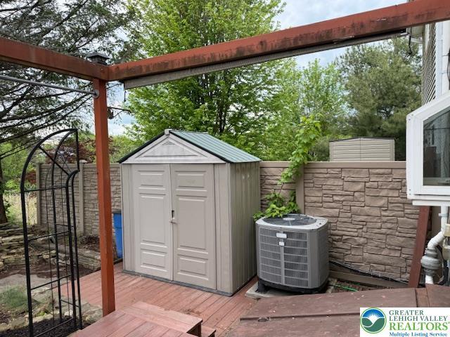 view of shed with central AC unit and a fenced backyard