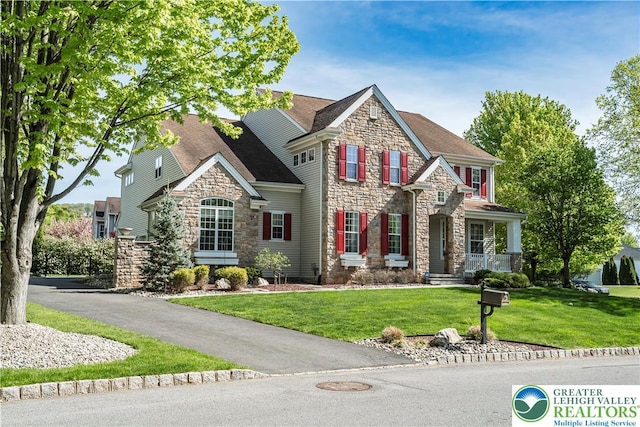 view of front of home featuring stone siding and a front lawn