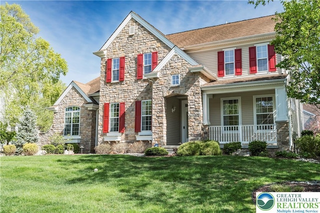 craftsman house with stone siding, covered porch, and a front lawn