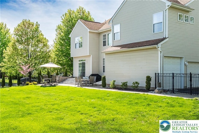 rear view of property with a patio area, an attached garage, and roof with shingles