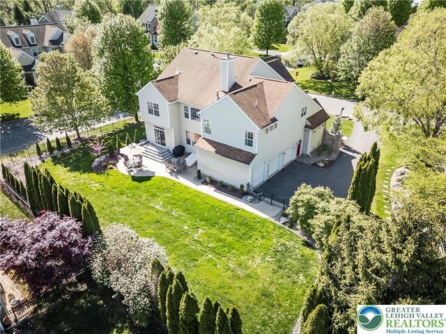 aerial view of property and surrounding area with a tree filled landscape