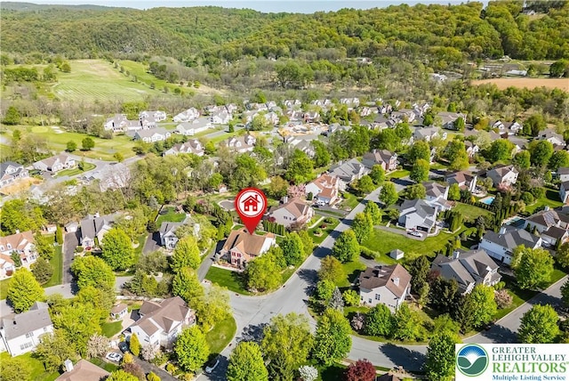 aerial view of residential area featuring a heavily wooded area