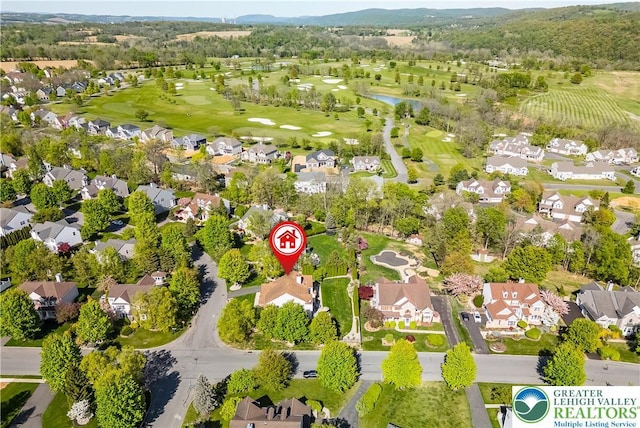 aerial perspective of suburban area with a golf course and a large body of water