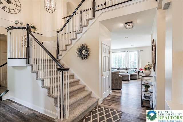 stairway with wood finished floors, baseboards, and recessed lighting