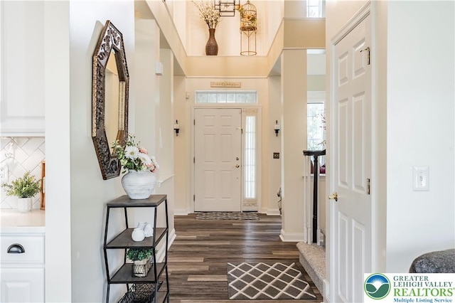 entryway with dark wood-style flooring and baseboards