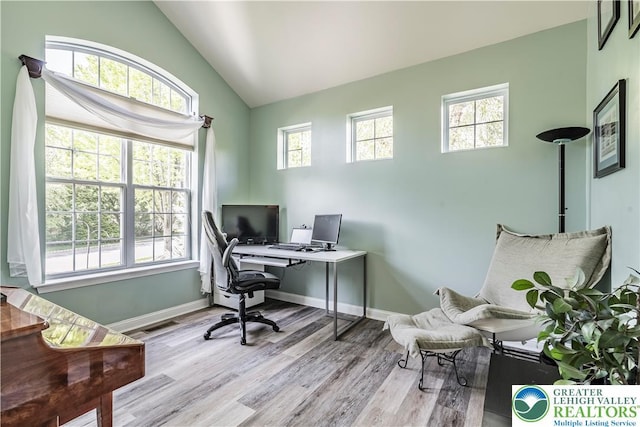 home office featuring lofted ceiling, wood finished floors, and baseboards