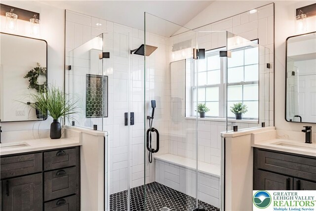 bathroom with a shower stall, vaulted ceiling, and vanity