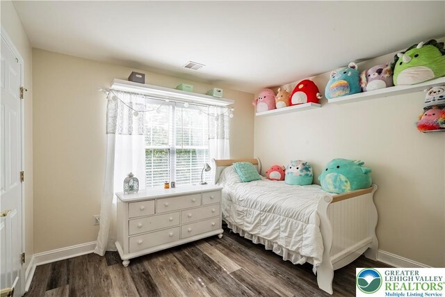 bedroom with dark wood-style floors and baseboards