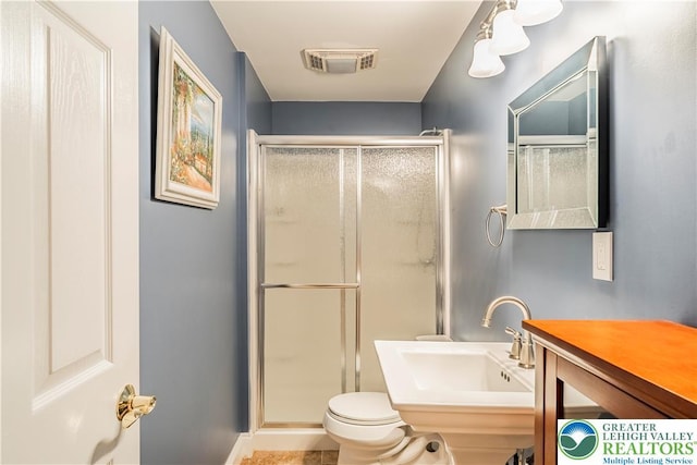 full bathroom featuring a stall shower, toilet, a sink, and baseboards