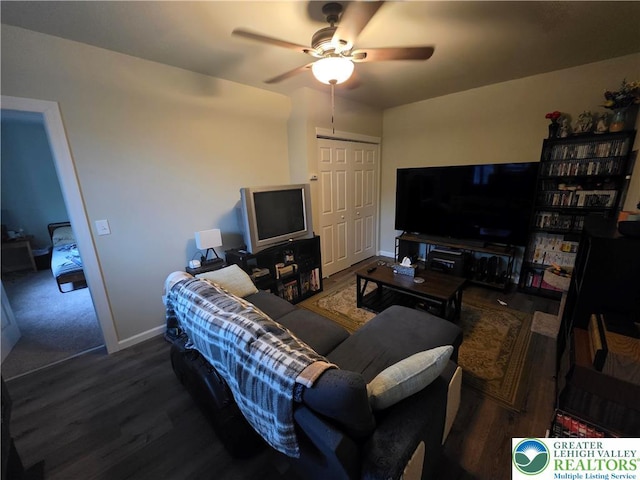 living room with a ceiling fan, baseboards, and wood finished floors