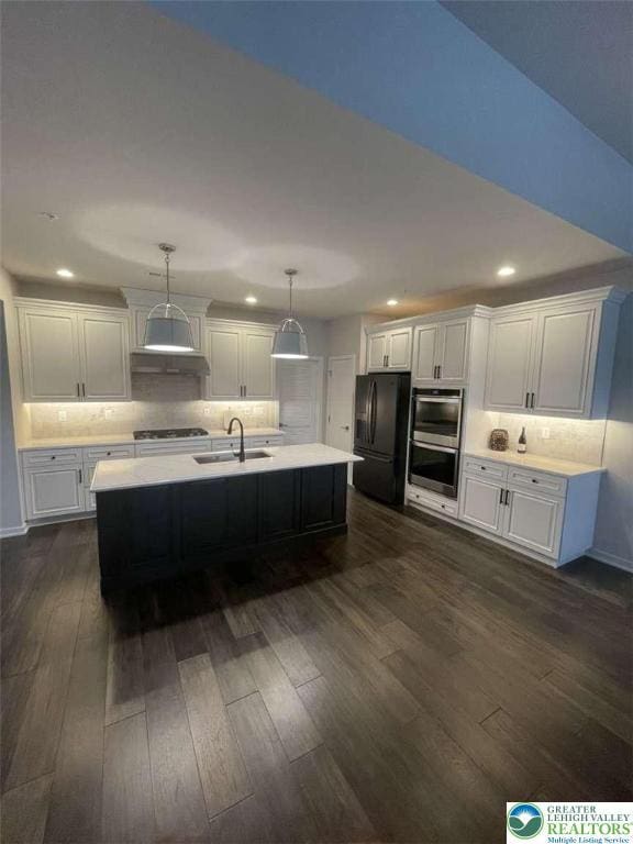 6907 Cedar Dr, East Allen Twp, PA 18014 - kitchen featuring freestanding refrigerator, stainless steel double oven, light countertops, dark wood-style flooring, and gas cooktop