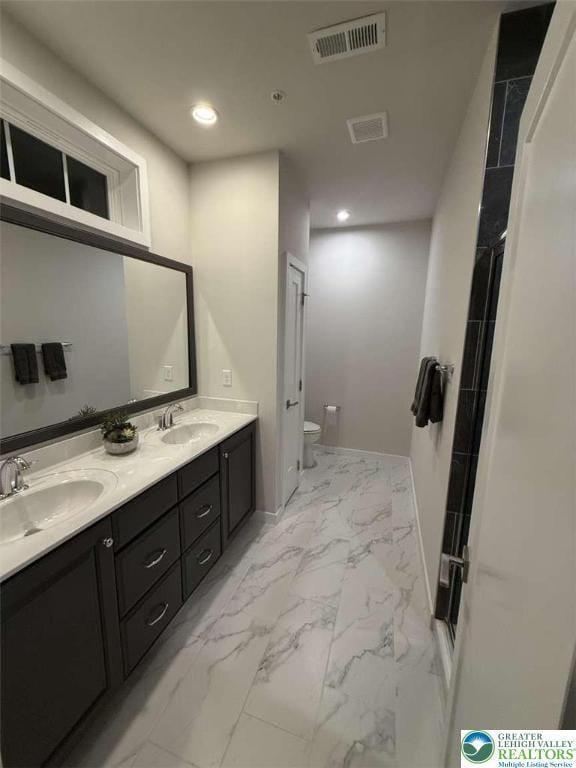 6907 Cedar Dr, East Allen Twp, PA 18014 - bathroom featuring toilet, marble look tile flooring, double vanity, recessed lighting, and baseboards
