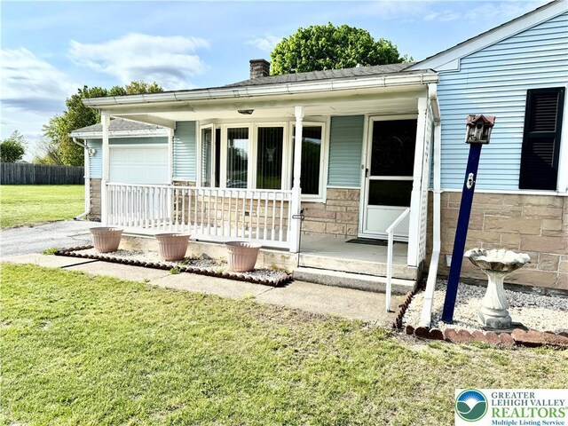 8173 Holbens Valley Rd, Weisenberg Twp, PA 18066 - ranch-style house featuring a porch, a chimney, a garage, and driveway
