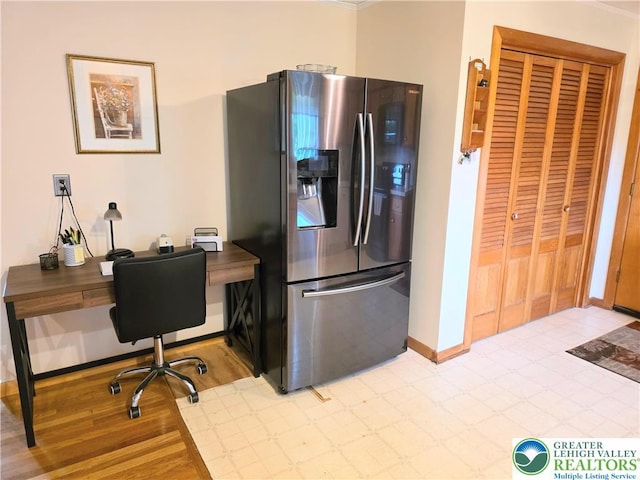 kitchen with stainless steel refrigerator with ice dispenser, baseboards, an office area, and light wood-type flooring