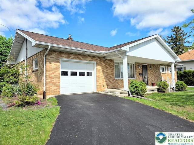 view of front of property featuring a garage, brick siding, covered porch, and asphalt driveway