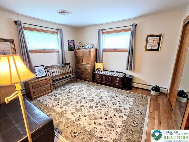 sitting room featuring wood finished floors and a baseboard heating unit