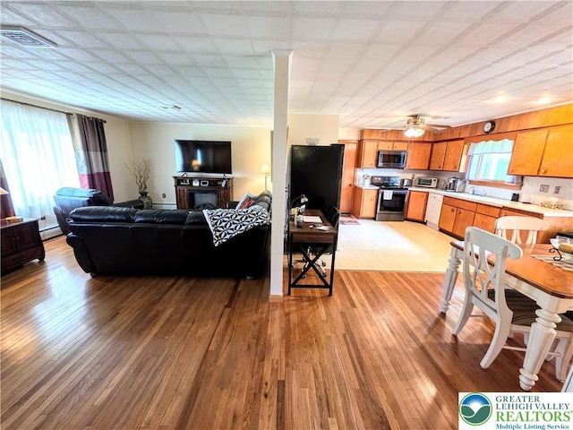living area featuring light wood-style flooring and baseboard heating