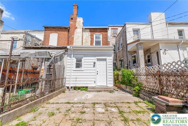 410 E Hamilton St, Allentown City, PA 18109 - rear view of house featuring fence, brick siding, and a chimney