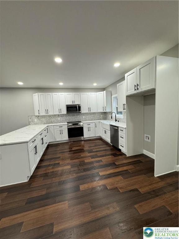 211 Maxatawny Dr, Coolbaugh Twp, PA 18347 - kitchen featuring stainless steel appliances, a peninsula, recessed lighting, decorative backsplash, and dark wood-style flooring